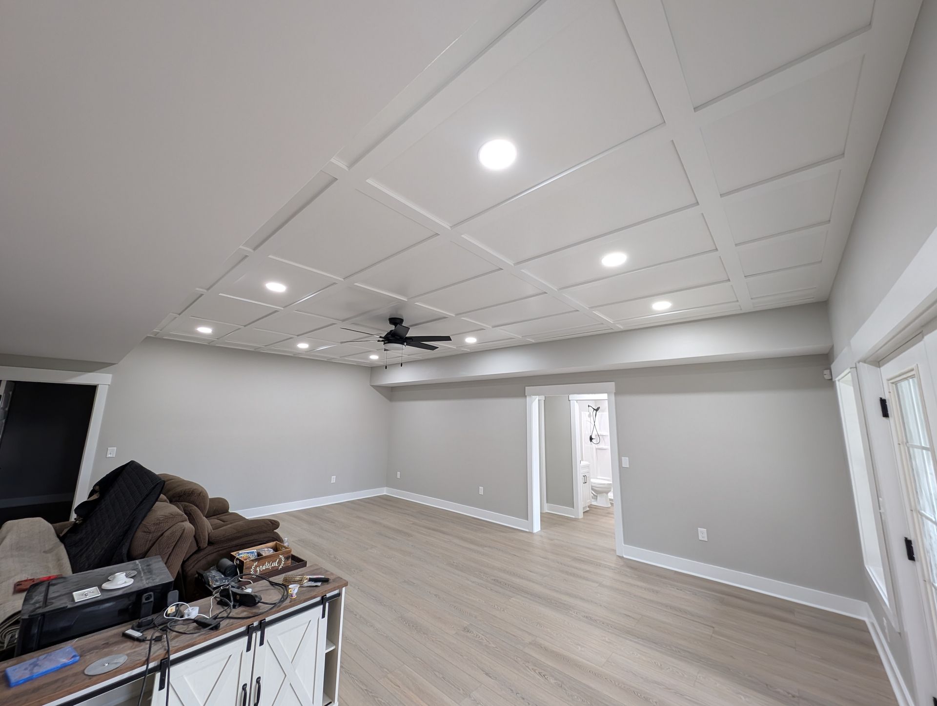 Renovated room with coffered ceiling, recessed lighting, and gray walls.