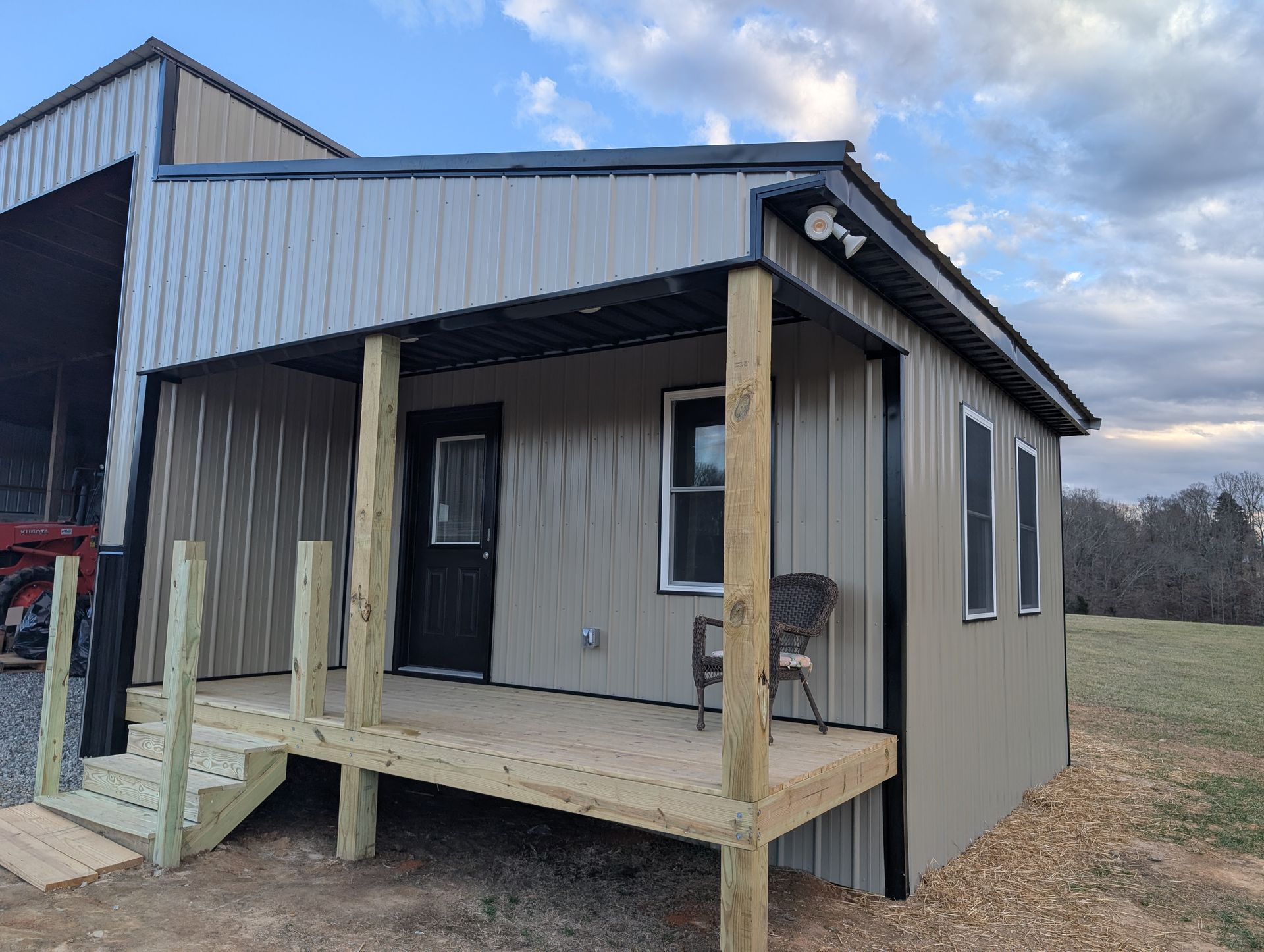 Small metal-sided building with a wooden porch and steps.