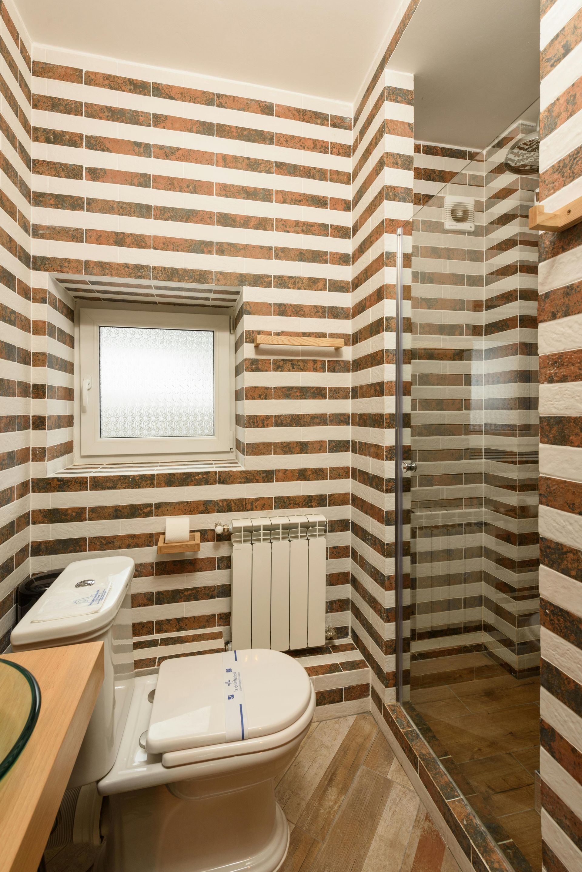 Compact bathroom with brown and beige striped tile design for small bathroom remodel Greensboro NC