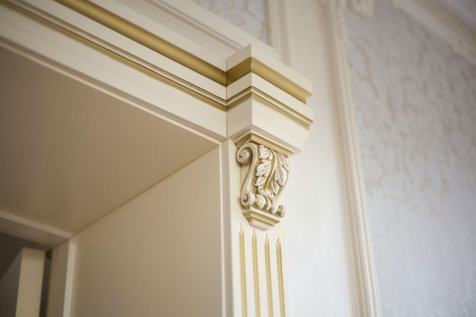 Cream-colored decorative wall molding with ornate column detail at an interior doorway