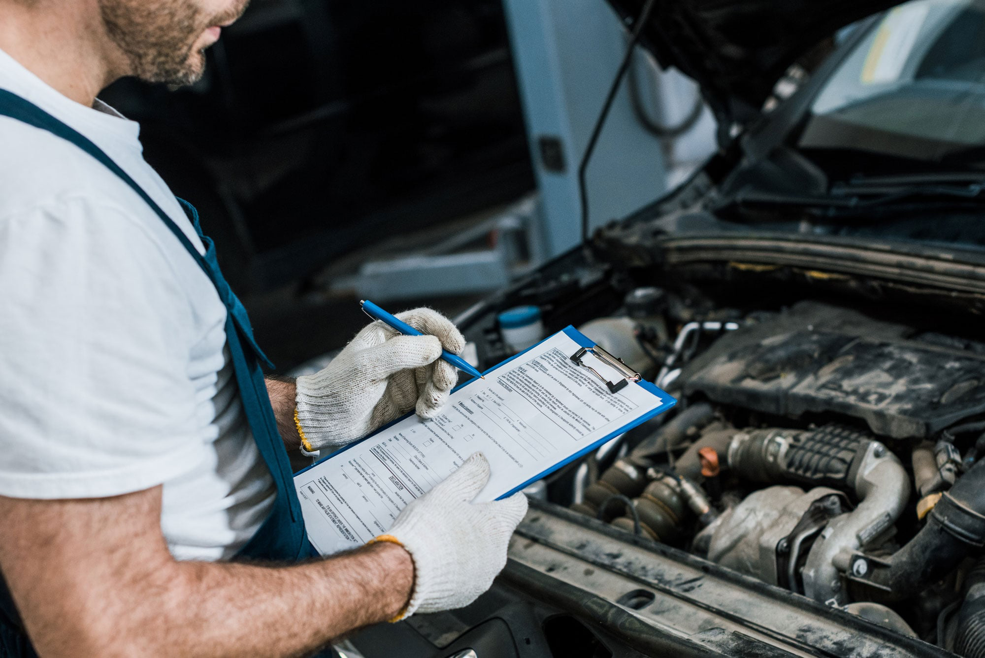 Car mechanic checking vehicle over