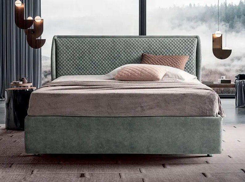 Letto moderno con testiera imbottita grigia e biancheria da letto color cipria in una camera da letto minimalista