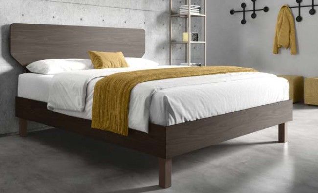 Letto moderno con testiera grigia, lenzuola bianche e plaid color senape in una camera da letto minimalista