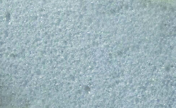 Superficie testurizzata di colore azzurro chiaro con un motivo punteggiato e granuloso