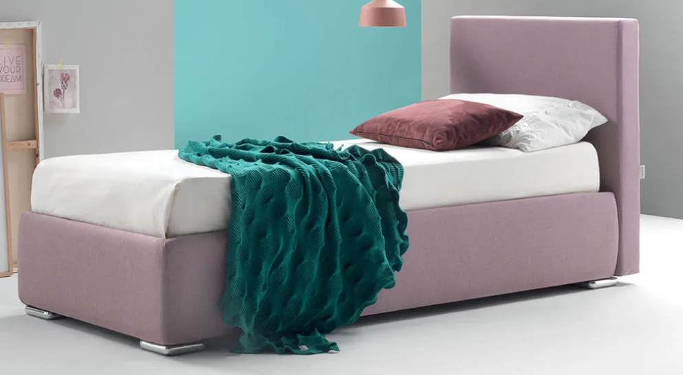 Letto imbottito rosa con lenzuola bianche, plaid color verde acqua e cuscino color malva in una camera da letto minimalista