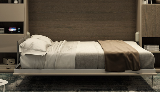 Un letto ben rifatto con lenzuola bianche e un plaid color beige in una moderna camera da letto rivestita in legno.