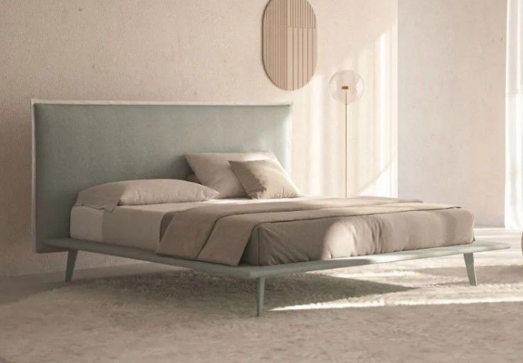 Camera da letto moderna con letto basso a piattaforma, biancheria da letto grigio tenue e arredamento minimalista.