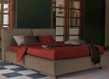 Camera da letto moderna con copriletto rosso, cuscini neutri e pavimento a piastrelle a scacchi.