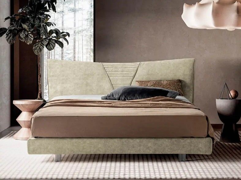 Camera da letto moderna con letto beige, biancheria da letto color tortora e una pianta in vaso vicino alla finestra.
