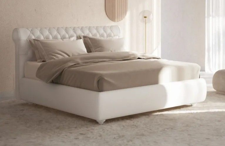 Camera da letto minimalista con letto imbottito bianco, biancheria da letto beige e tende trasparenti in una morbida luce naturale.