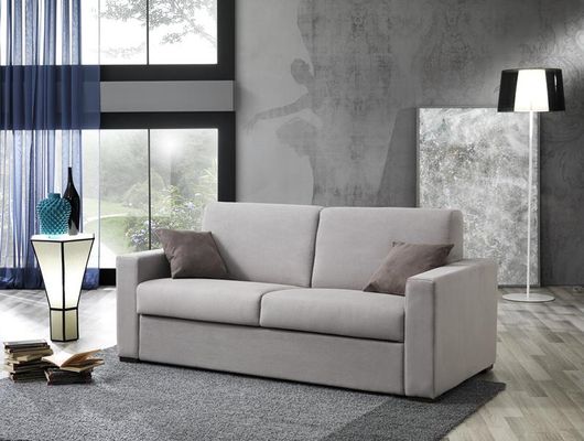Soggiorno moderno con divano beige, lampada da terra, tende blu e pareti grigie con texture.