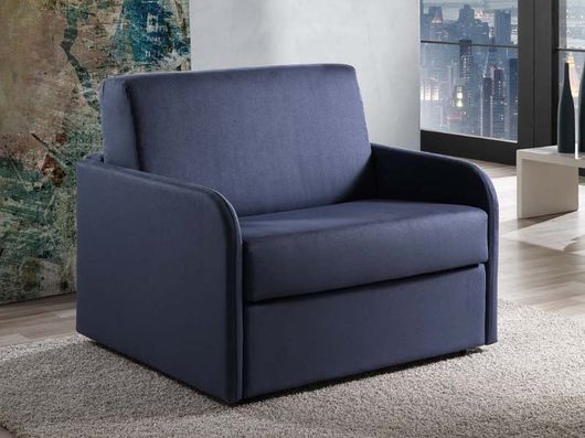 Poltrona imbottita blu in una stanza moderna con tappeto e vista sulla città.