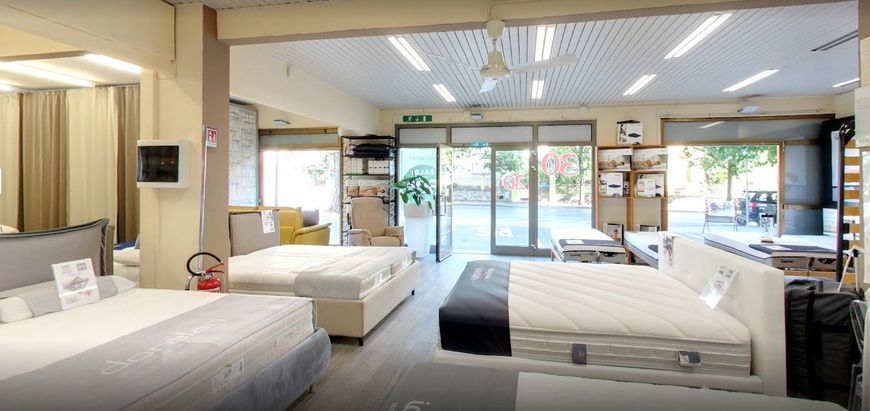 Luminosa camera da letto moderna con tre letti, ampie finestre e zona salotto con vista sul patio.