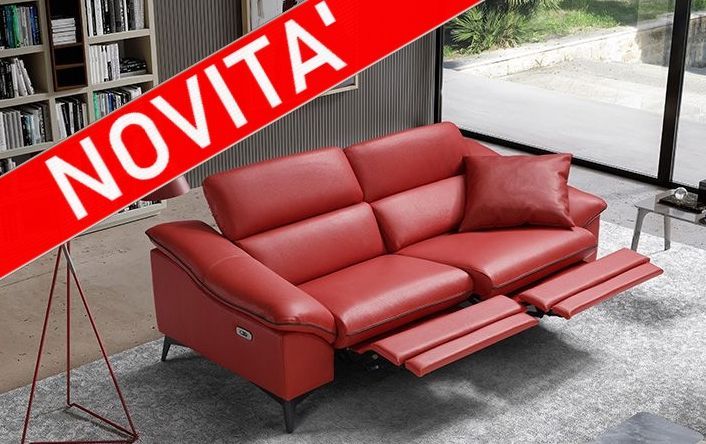 Divano componibile in pelle rossa con poggiapiedi reclinabili, esposto in uno showroom; striscione “NOVITÀ” nell'angolo.