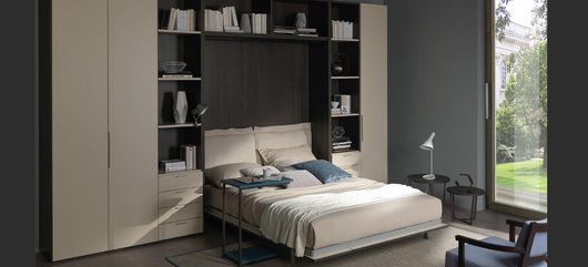 Camera da letto moderna con letto a incasso in legno scuro, mobili bianchi e un'ampia finestra con vista sul verde.