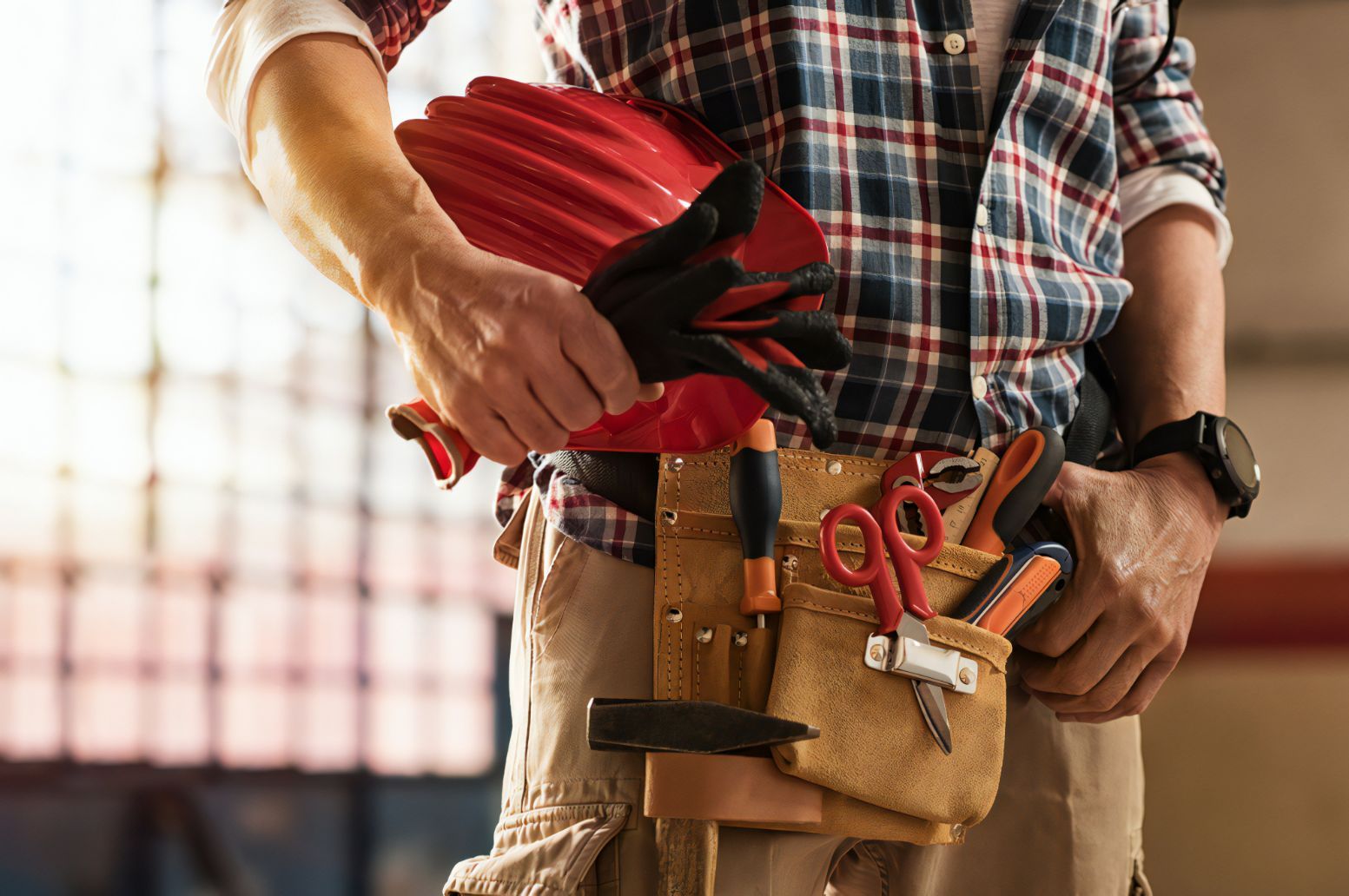 Man Holding Hard Hat & Construction Equipment — Cemak Constructions in Port Macquarie, NSW