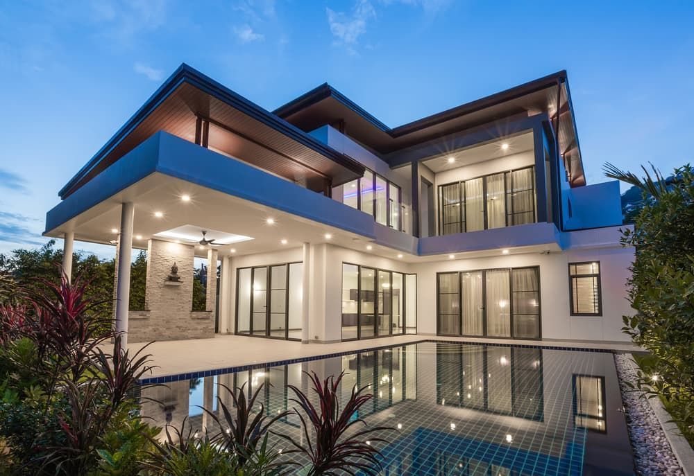 A Large House with A Swimming Pool in Front of It — Cemak Constructions in Wingham, NSW