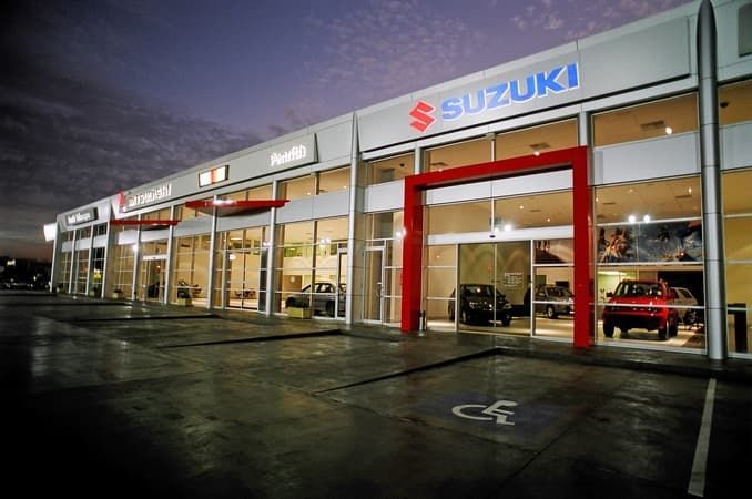 A Row of Cars Are Parked in Front of A Suzuki Dealership — Cemak Constructions in Port Macquarie, NSW