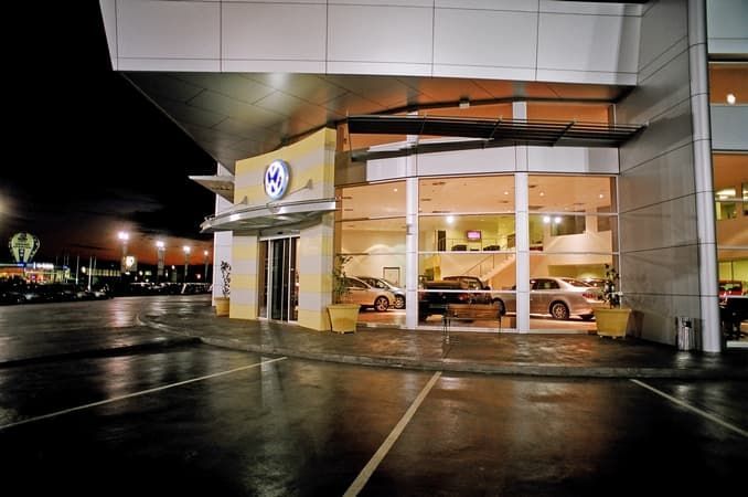 A Car Dealership with Cars Parked Outside at Night — Cemak Constructions in Port Macquarie, NSW