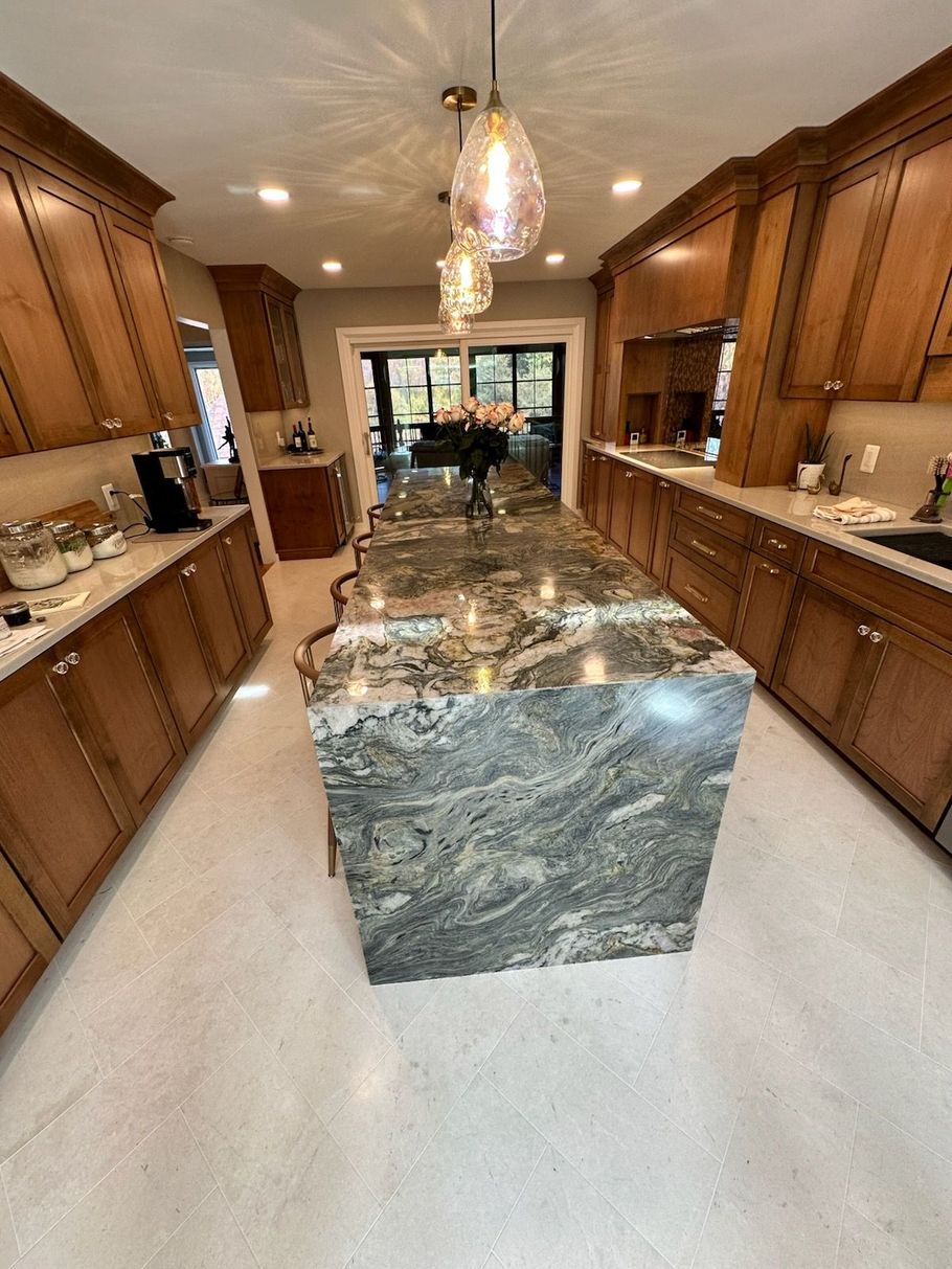 Modern kitchen with wood cabinets and a large marble island centerpiece
