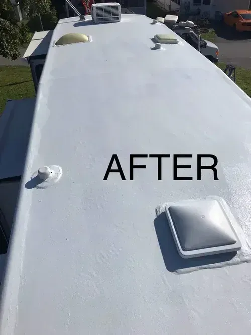 White RV roof after coating, with vents and skylight visible.
