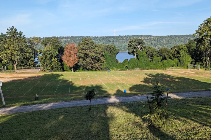 Aerial view of a sports complex with football field, track, swimming pool, and multiple outdoor courts