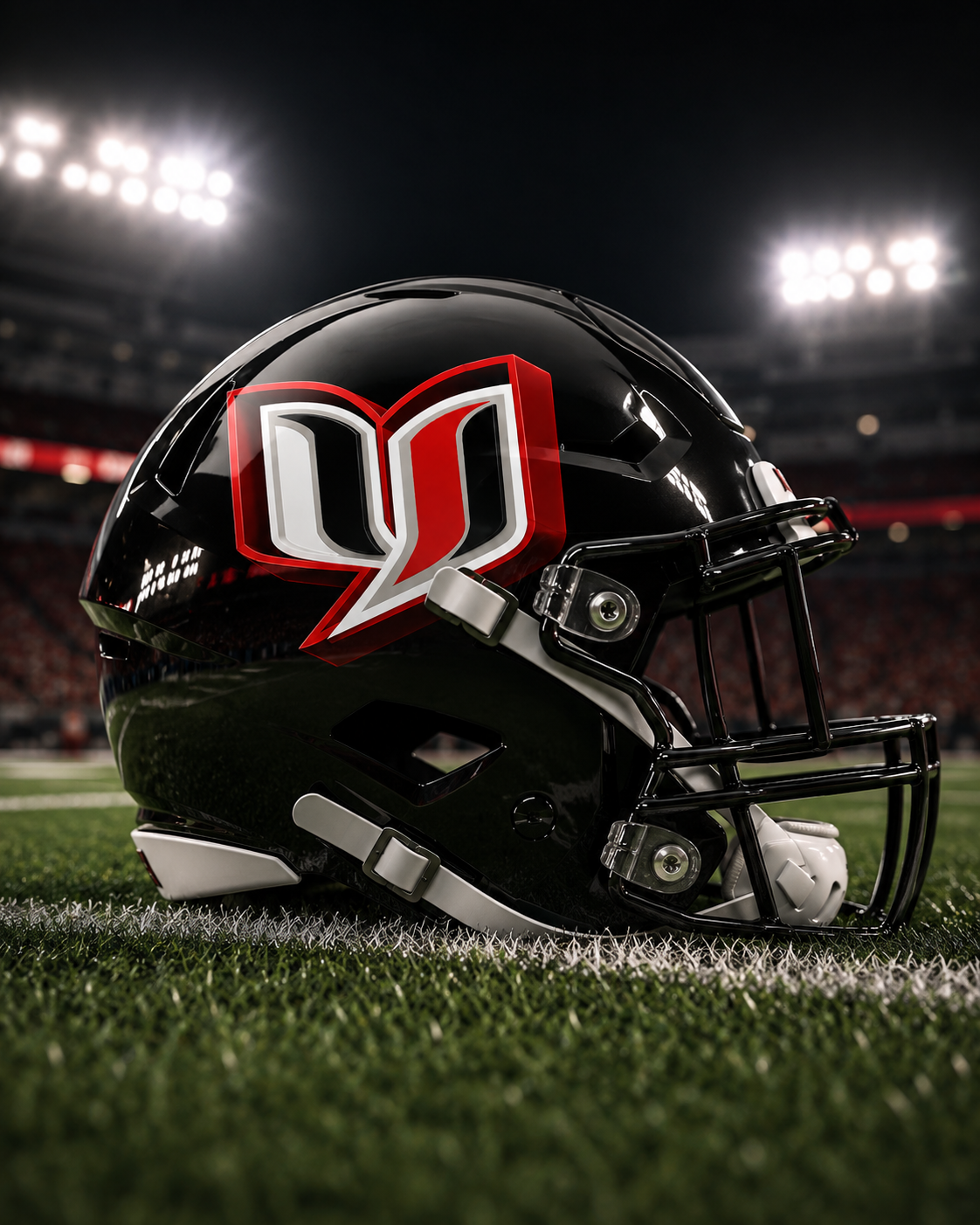Black football helmet with red-and-white logo on a field under stadium lights