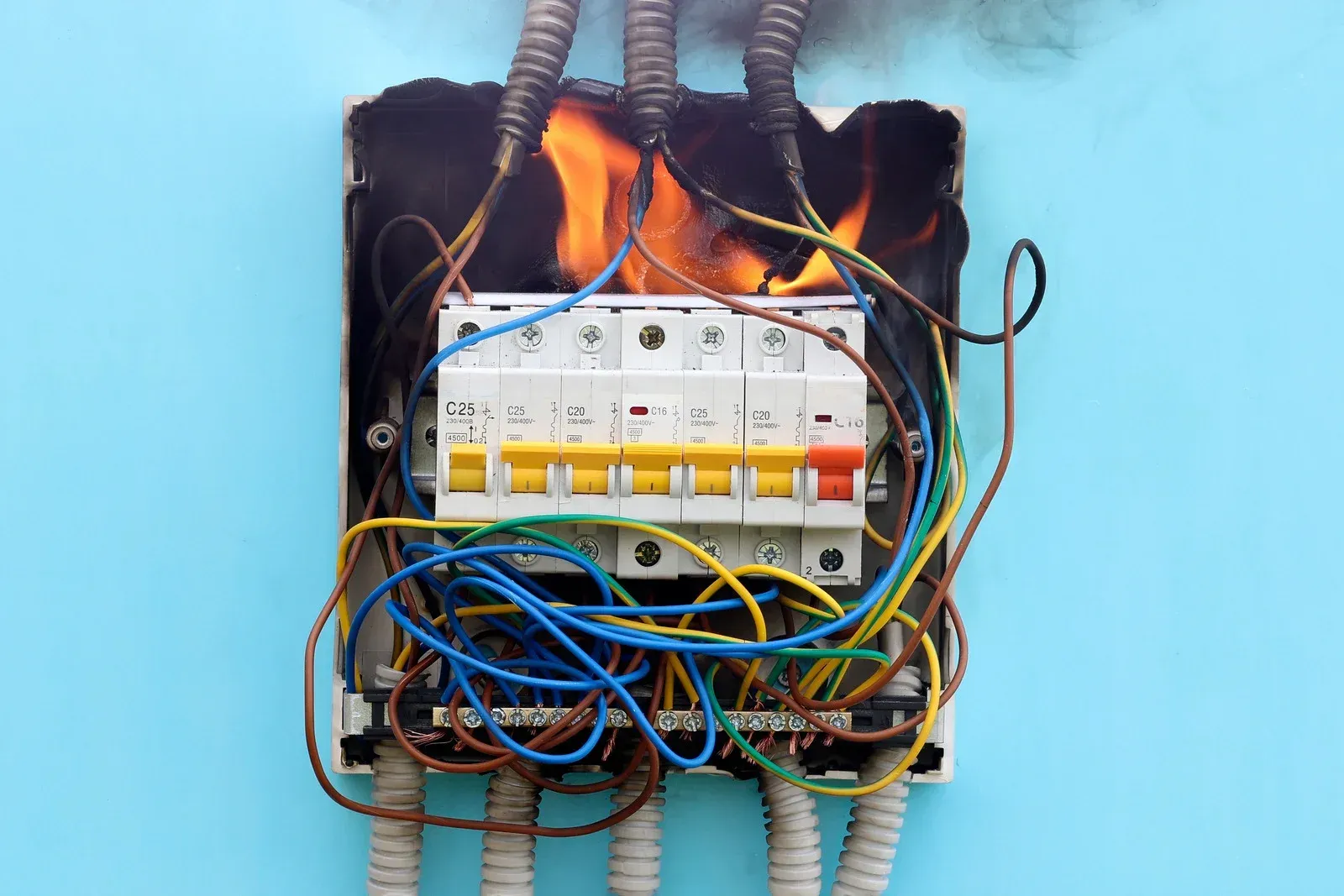 A person is looking at an electrical box with a flashlight.