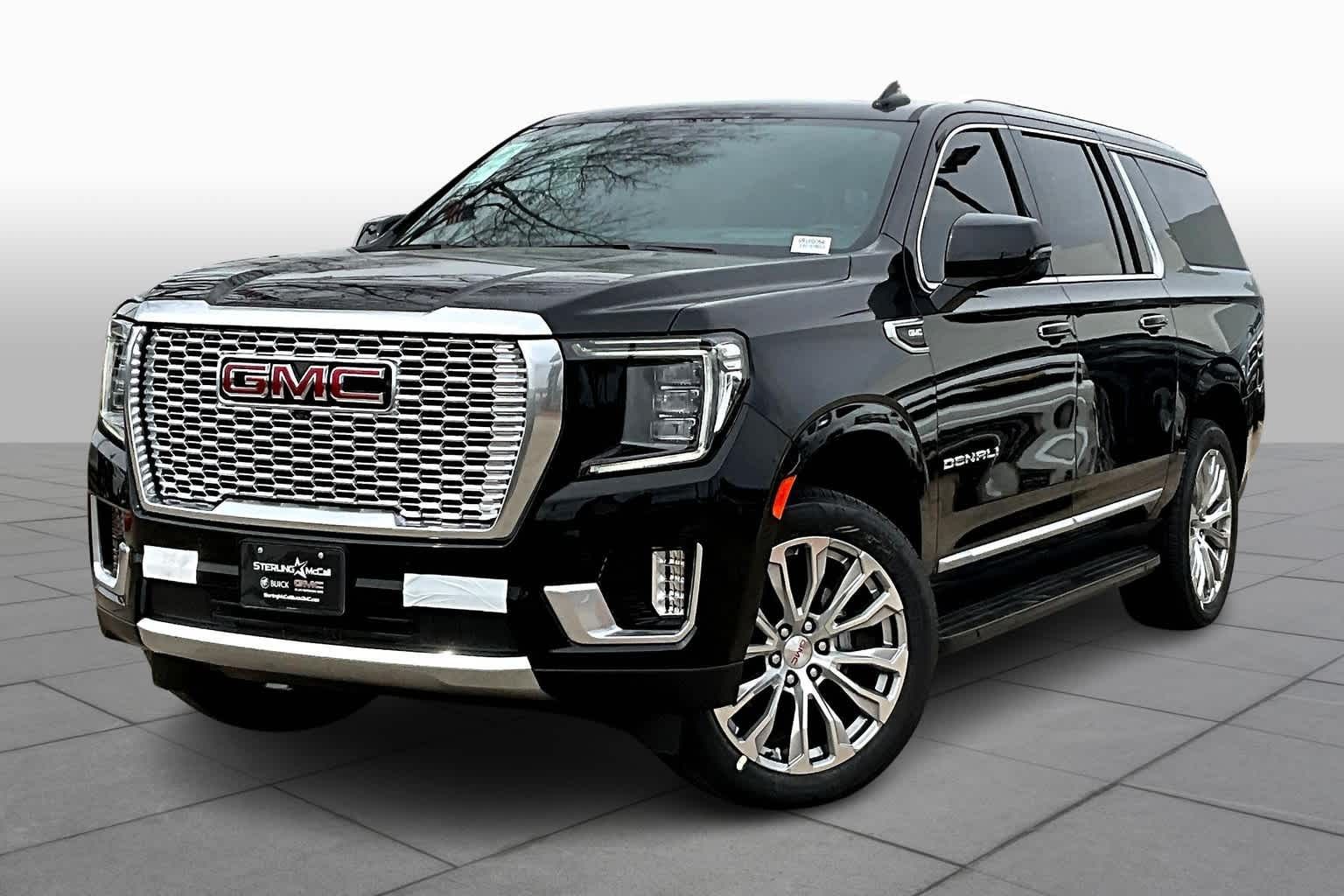 Black GMC Yukon SUV with chrome grille, wheels, and trim.