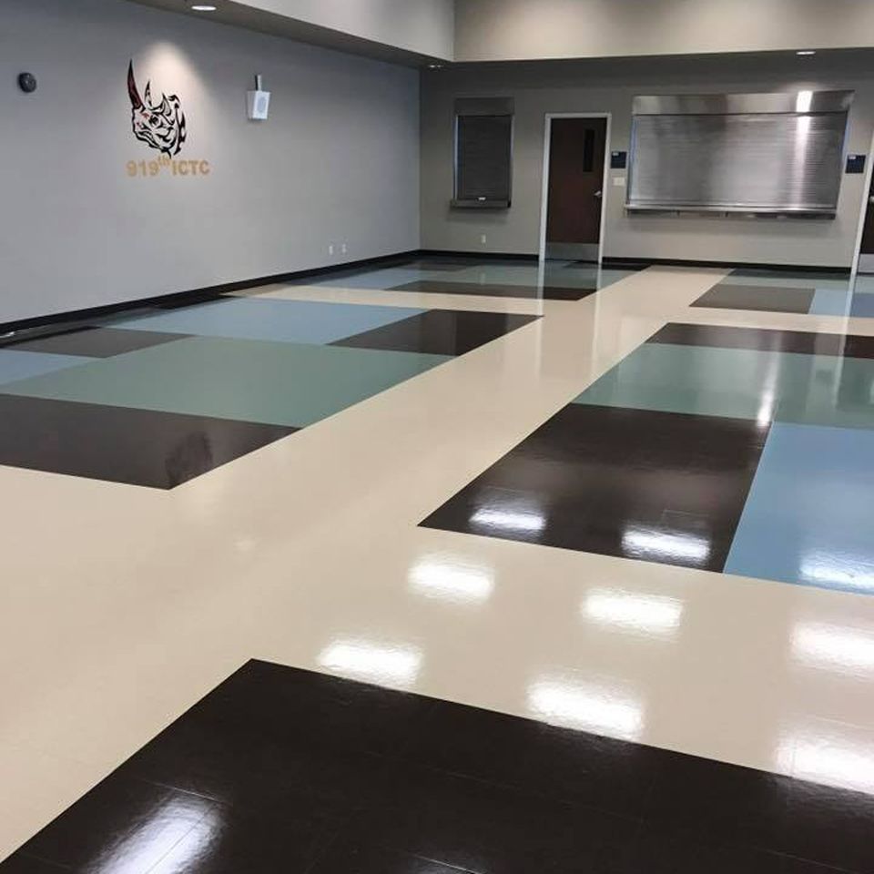 Shiny floor with colorful squares in a commercial space. A logo is on the wall.