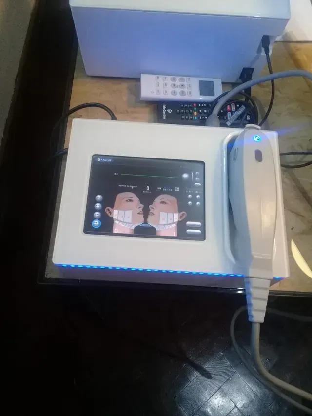 Tableta con caras de dibujos animados en la pantalla junto a un teléfono blanco sobre un escritorio.