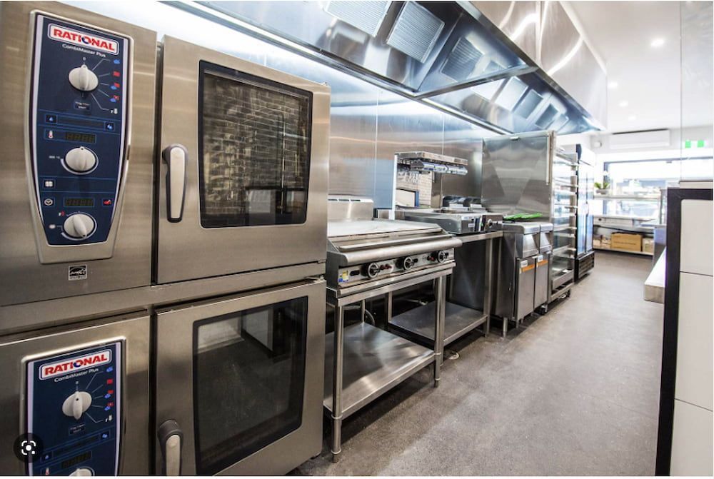 A kitchen with a lot of stainless steel appliances — Darwin’s Gas Man in Marrara, NT