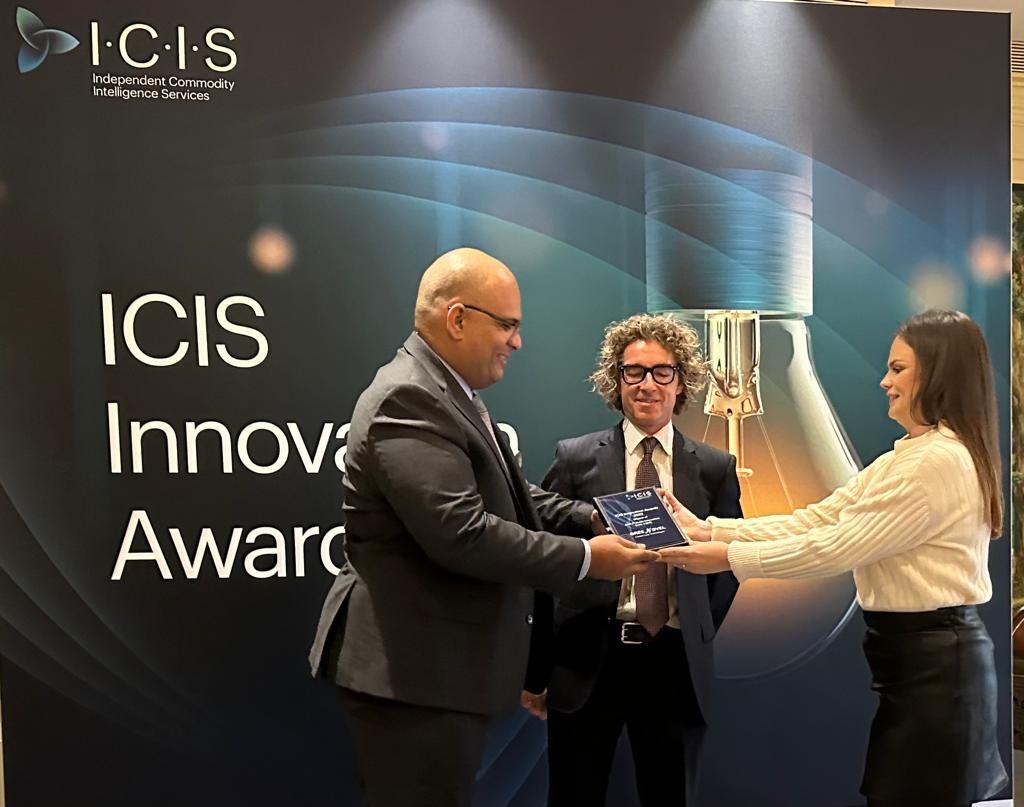 Two men and a woman are standing in front of a sign that says icis innovation award