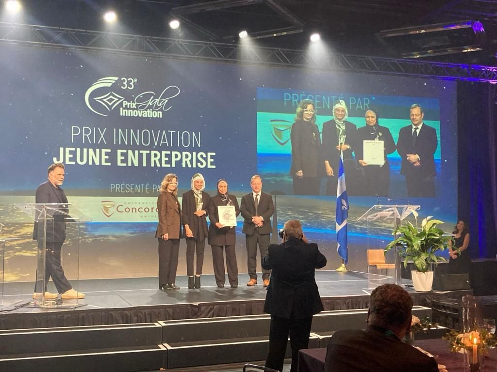 A group of people are standing on a stage holding awards.