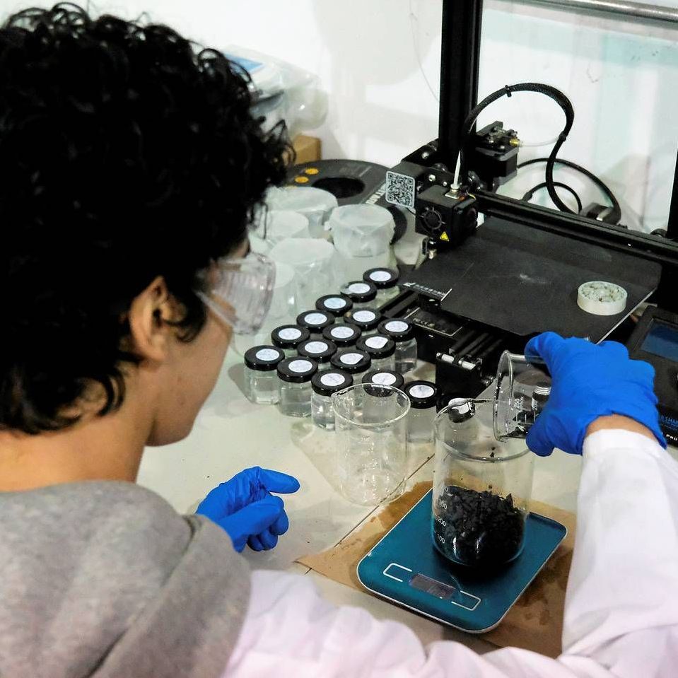 A person wearing blue gloves is working in a lab