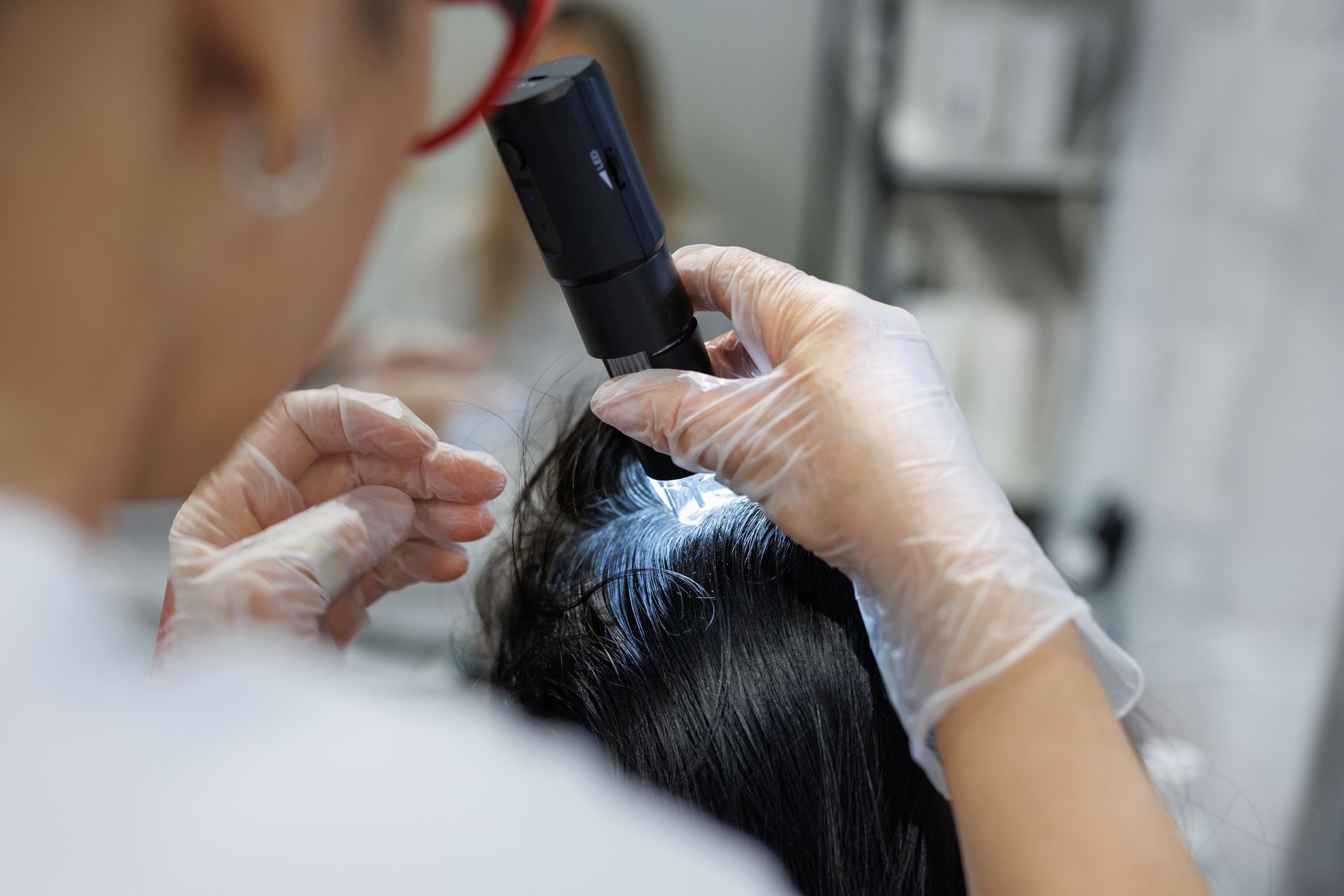 A woman is looking at her hair with a microscope.