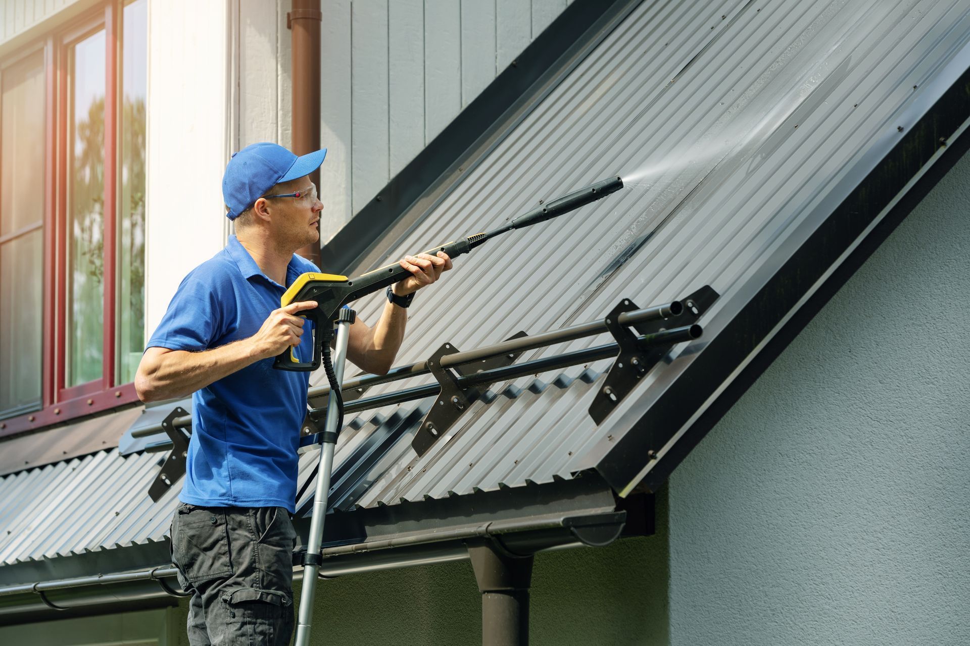 A person cleaning a roof with a pressure washer | Roof Soft Washing in Lake Mary FL
