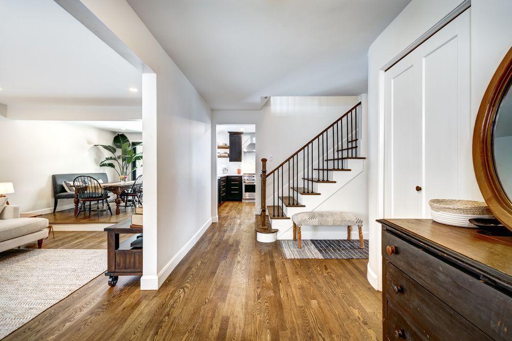 A Hallway With Hardwood Floors And Stairs In A House — B2B Flooring Solutions In Coffs Harbour, NSW