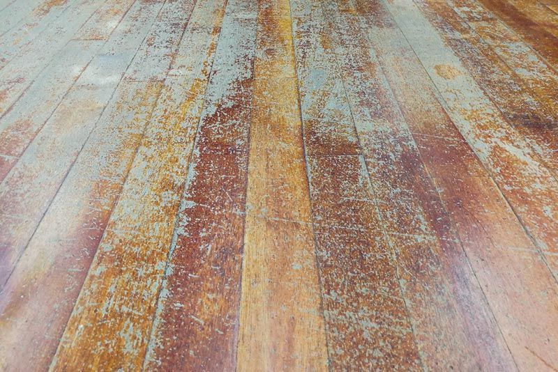 A Close Up Of A Wooden Floor With A Lot Of Stains On It — B2B Flooring Solutions In Coffs Harbour, NSW