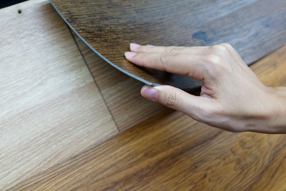 Close Up Female Hand Holding A Wood Texture Floor Samples Of Laminate — B2B Flooring Solutions In Coffs Harbour, NSW