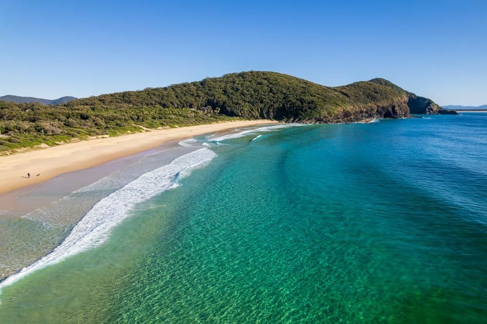 An Aerial View Of A Beach And Ocean With Mountains In The Background — B2B Flooring Solutions In Clarence Valley, NSW