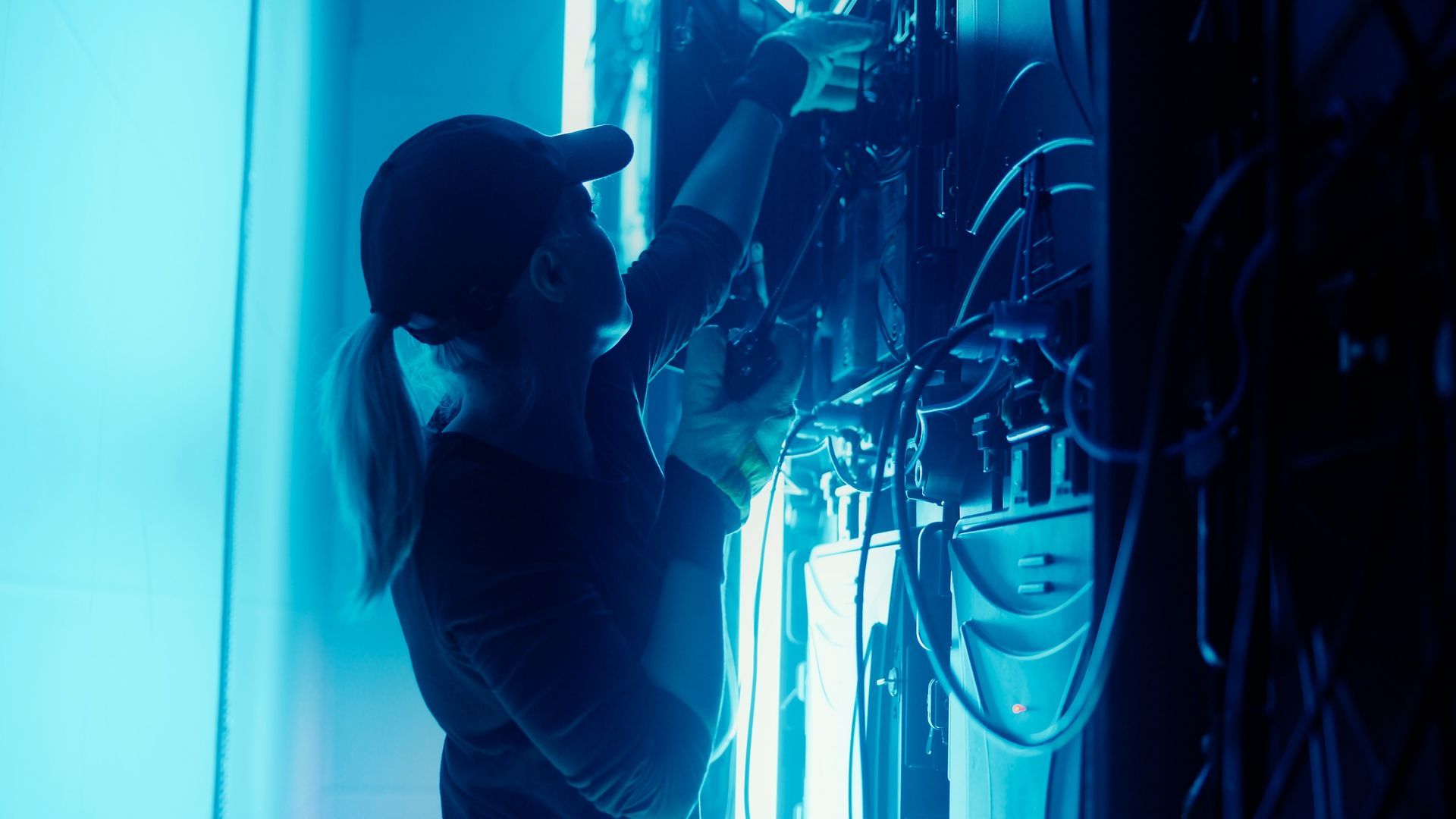Woman In Cap Works On Wires In Blue-lit Room — HYVIS Pty Ltd in Mulambin, QLD