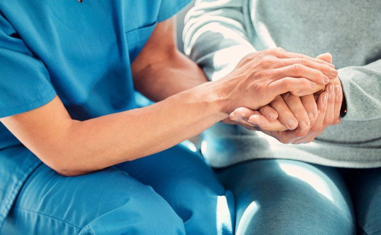nurse offering her elderly female patient support