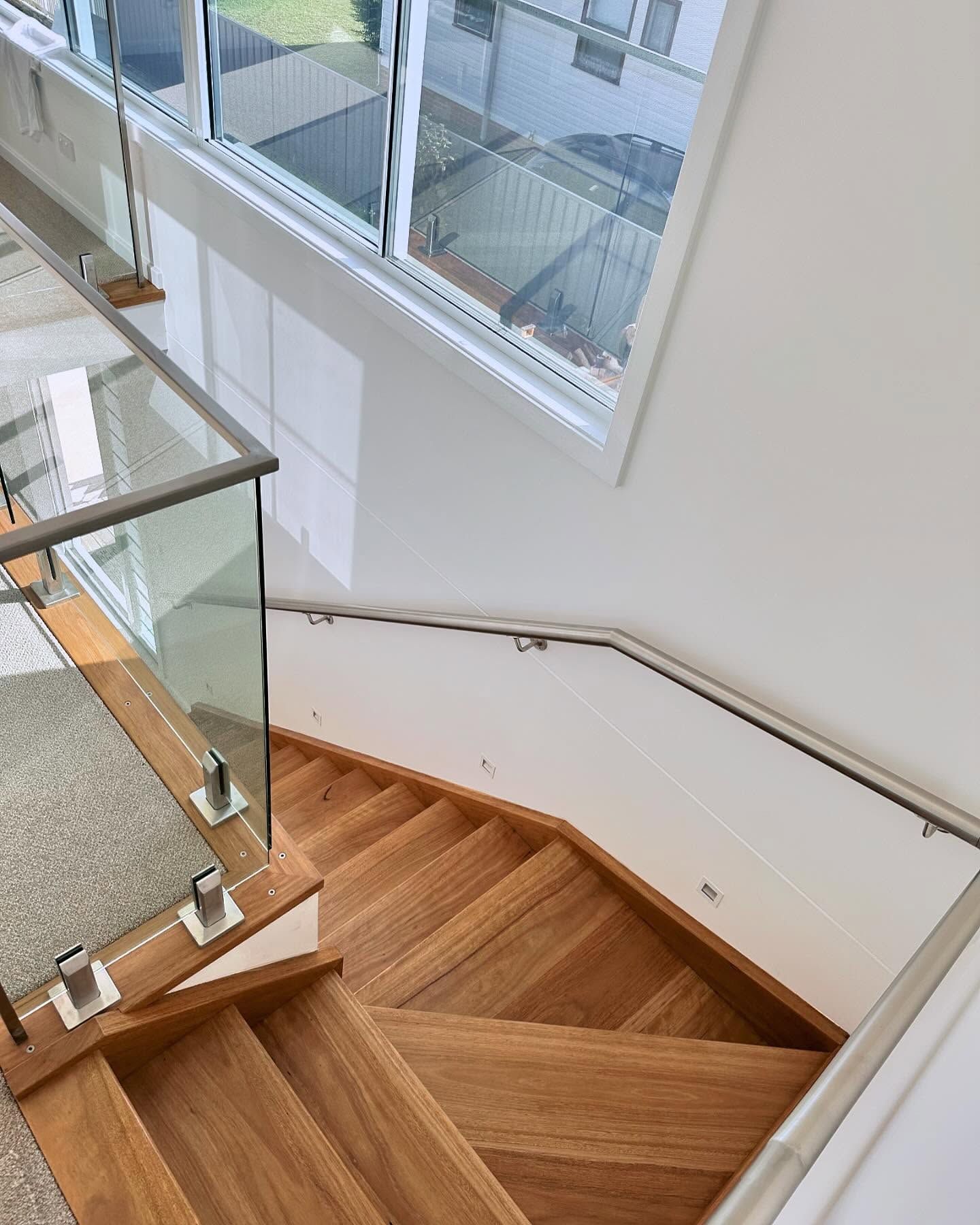 Wooden stairwell with glass railing and large windows — Wade Adams Constructions in Forster, NSW