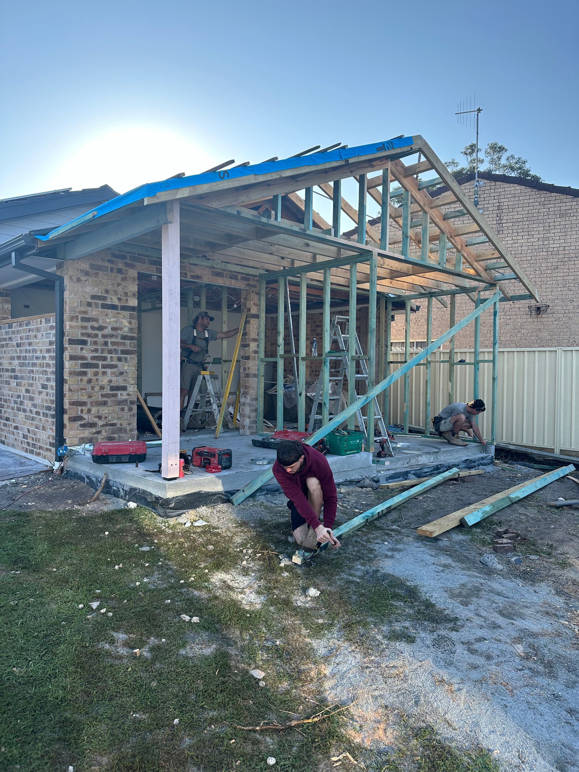 Person working on a house addition with exposed framing — Wade Adams Constructions in Gloucester, NSW