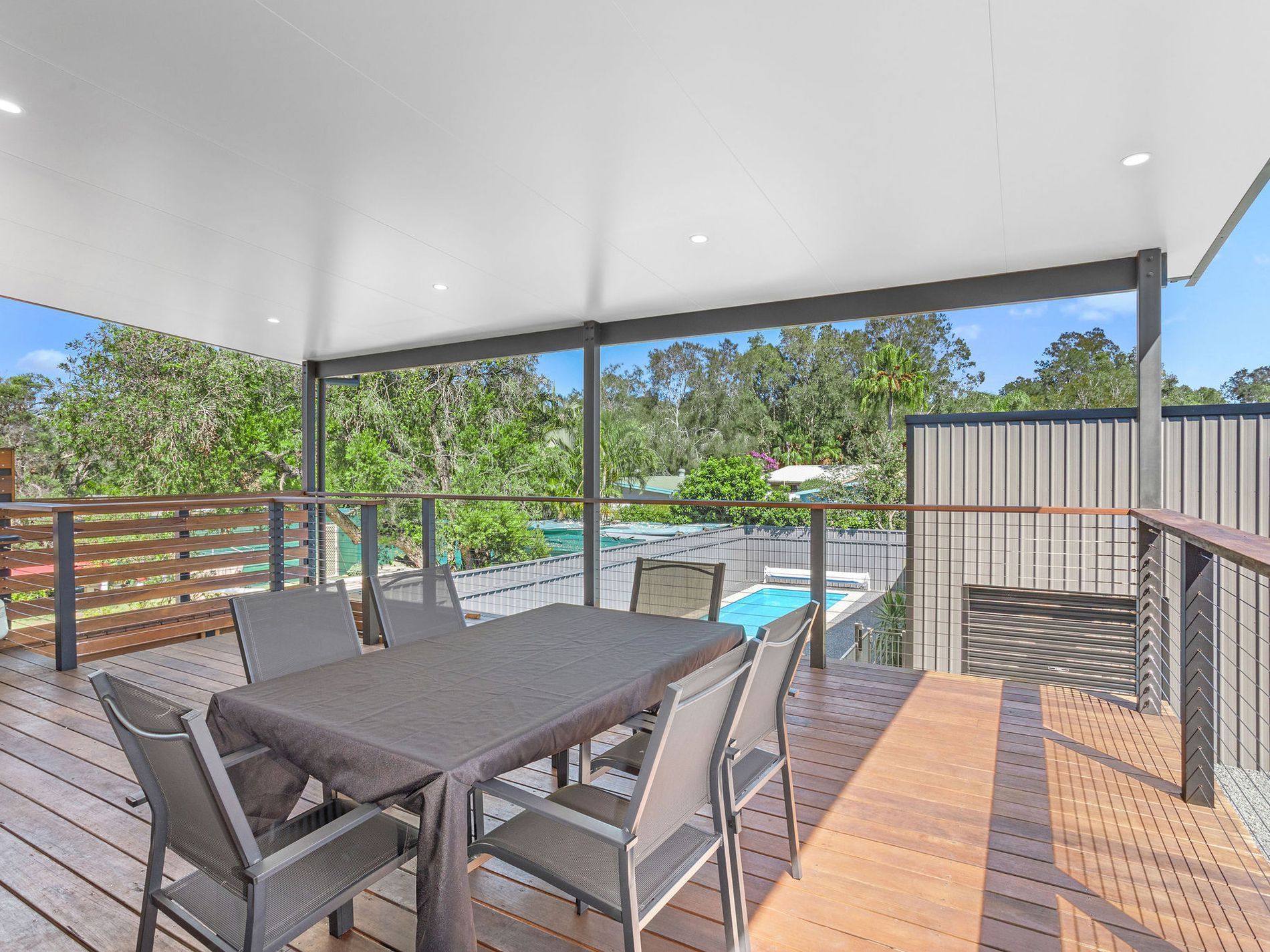 Covered patio with dining table and chairs overlooking a backyard pool — Wade Adams Constructions in Gloucester, NSW