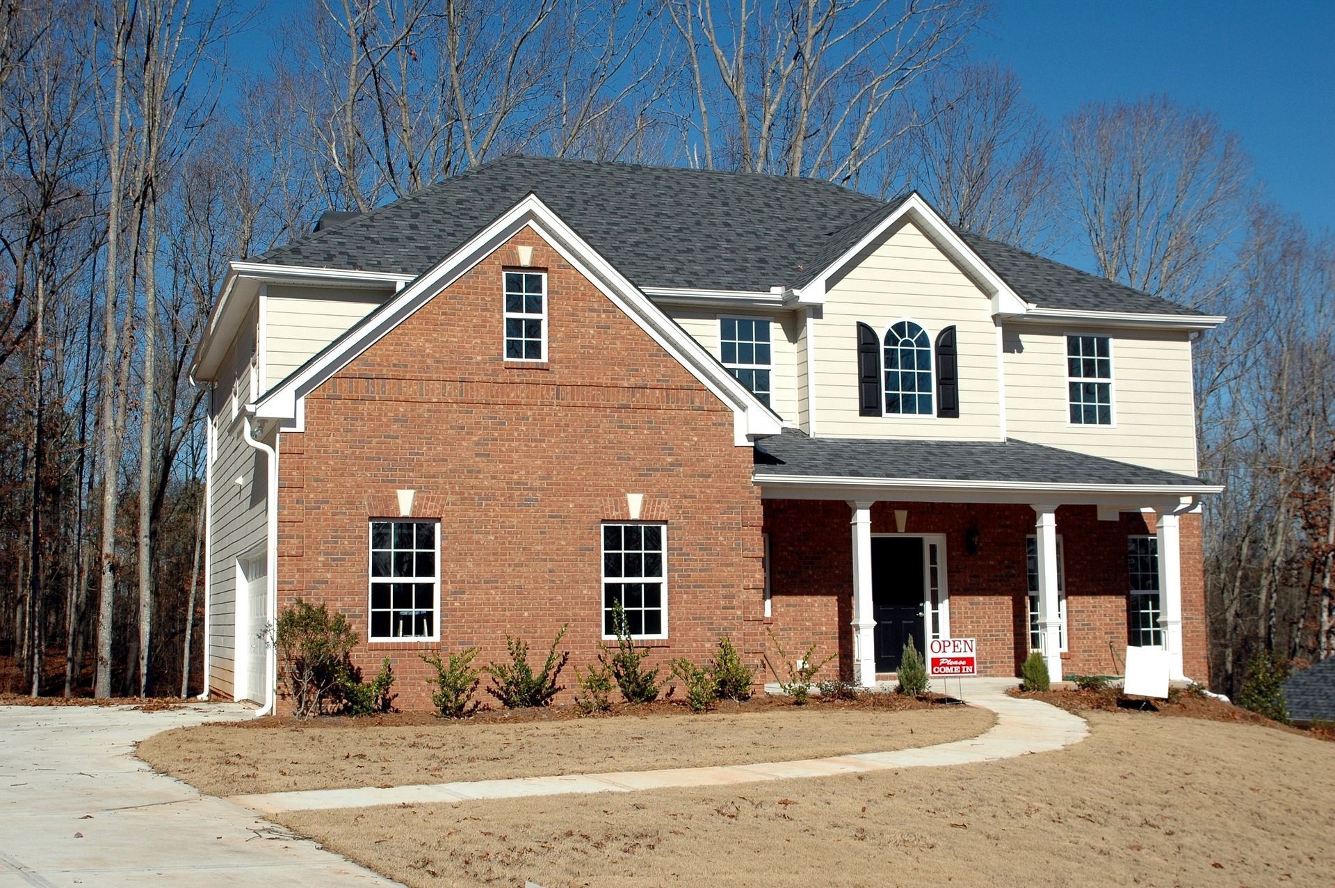 a large brick house with a white siding is for sale