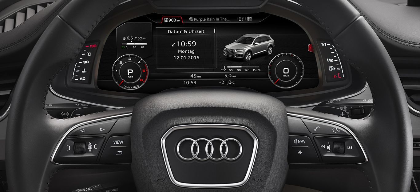 Armaturenbrett eines Audi-Autos mit Lenkrad; die digitale Anzeige zeigt Fahrzeugdaten und ein Automodell an.