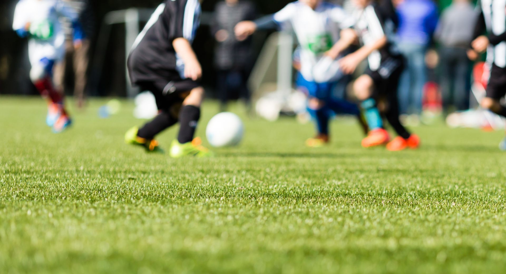 travel soccer players fighting for a soccer ball on a grass field