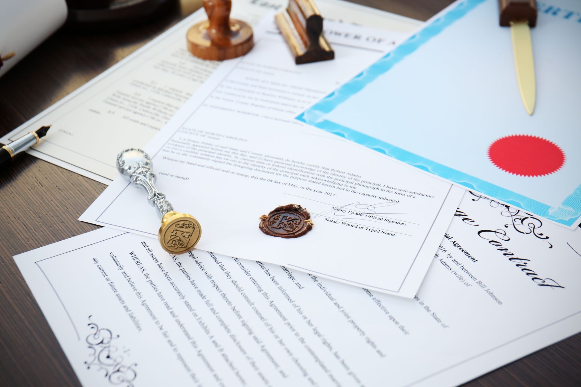 Open documents with wax seals, a pen, and a blue folder on a desk